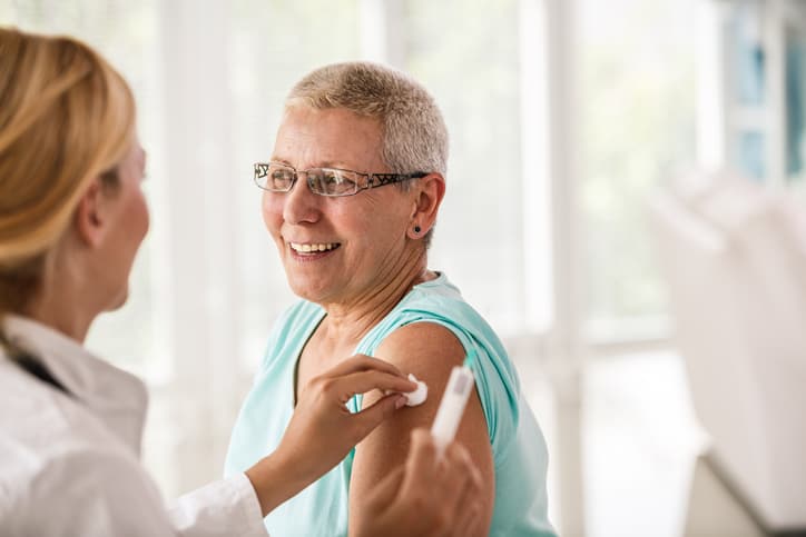 Senior woman receiving vaccine at the doctor's office.
