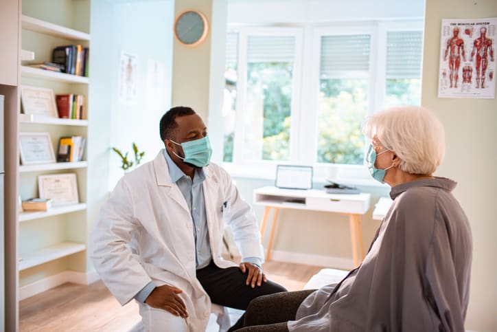 Senior woman at a doctor's appointment regarding COVID-19 rehab