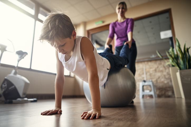 Little boy doing proprioceptive exercises with occupational therapist