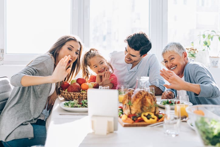 Fully vaccinated older woman dining indoors with her family without wearing mask