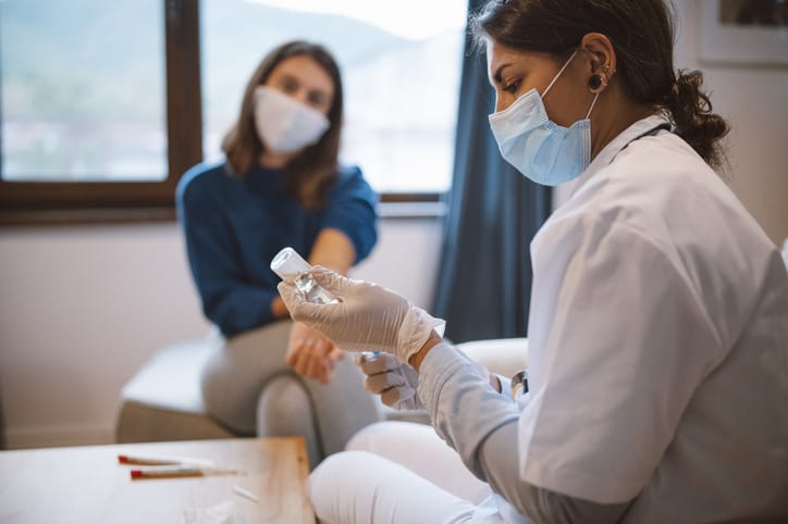 Female travel nurse preparing to vaccinate patient