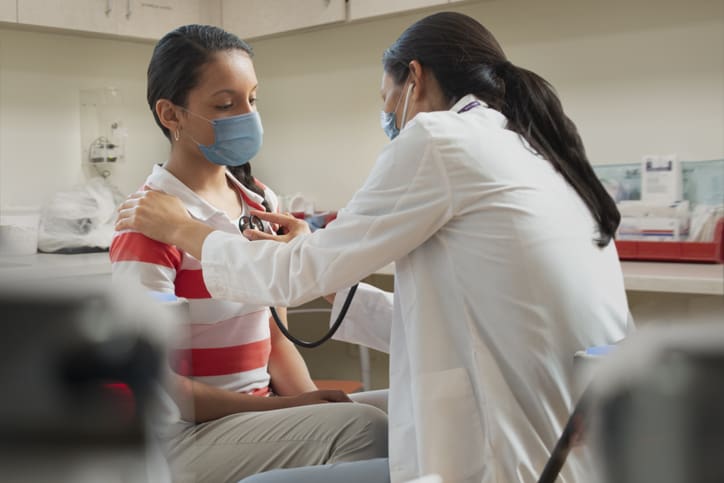 Doctor examining teen girl patient at hospital