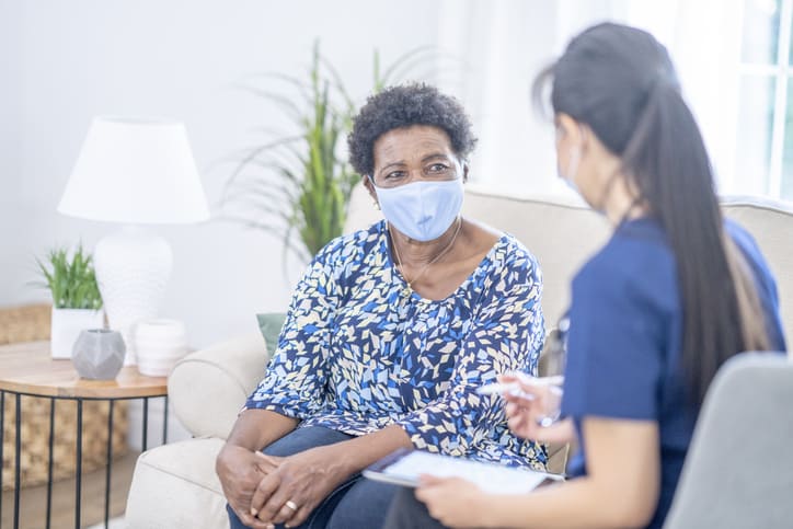 Nurse discusses COVID-19 vaccine hesitancy with patient during home visit