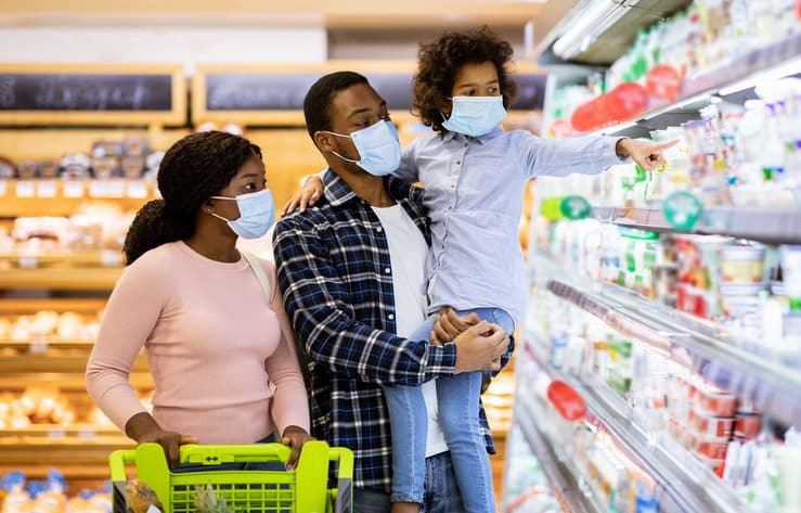 Family wearing face masks shopping at grocery store during coronavirus pandemic