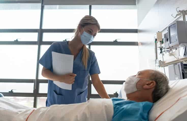 Nurse wearing a facemask while checking on a patient at the hospital during the COVID-19 pandemic