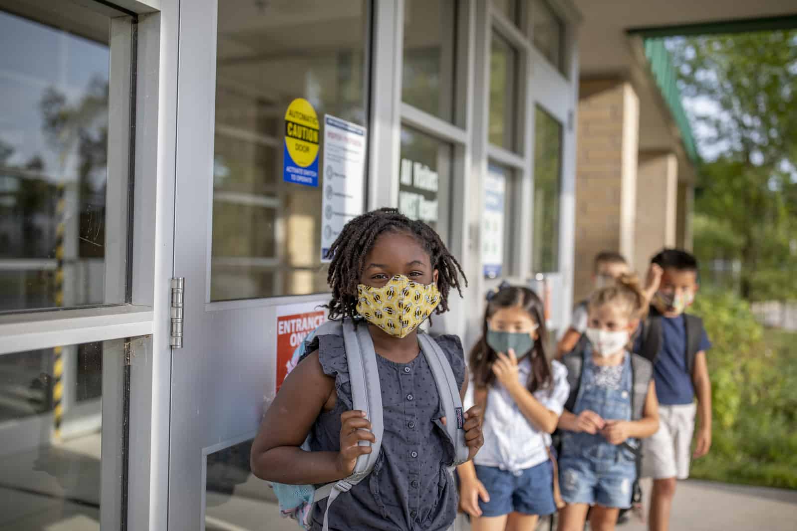 Group of kids return to school wearing face masks during the pandemic