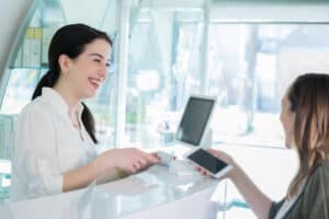 Female hair salon customer uses contactless payment, how to price your cosmetology services concept