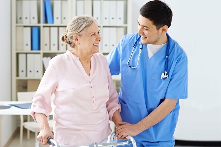 Senior woman with walker receives rehabilitatve services from healthcare worker