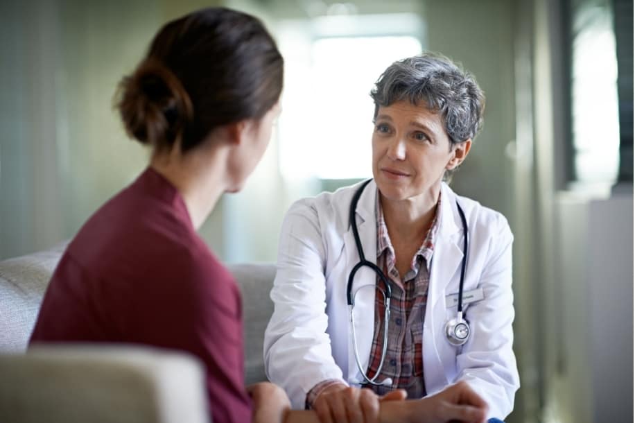 Healthcare professional shows compassion while speaking with a young woman about domestic violence