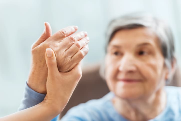 A senior woman receiving physical therapy, sensory reeducation exercises for the hand