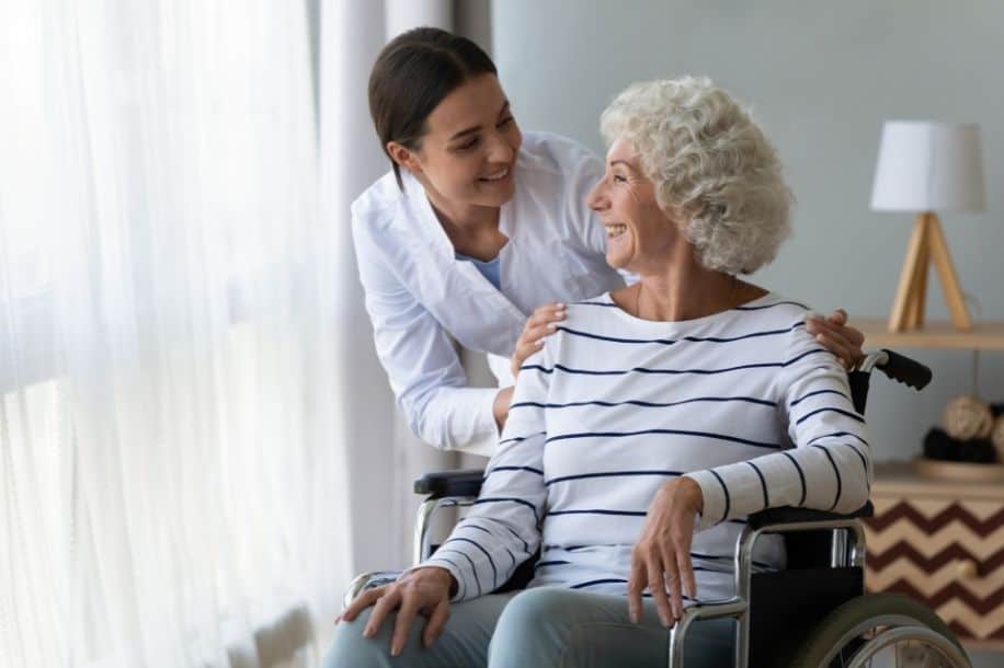 Healthcare professional with elderly female patient in wheelchair, dementia care model concept