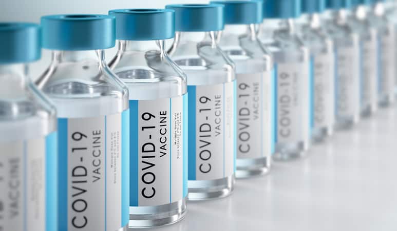 Row of Covid-19 vaccine flasks on white background