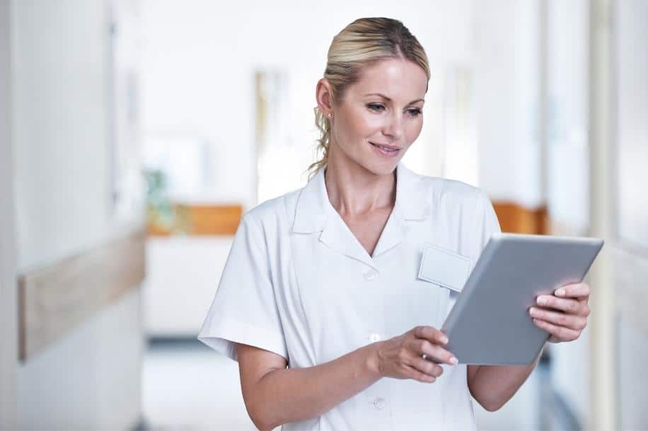 Nurse reads industry news on digital tablet 